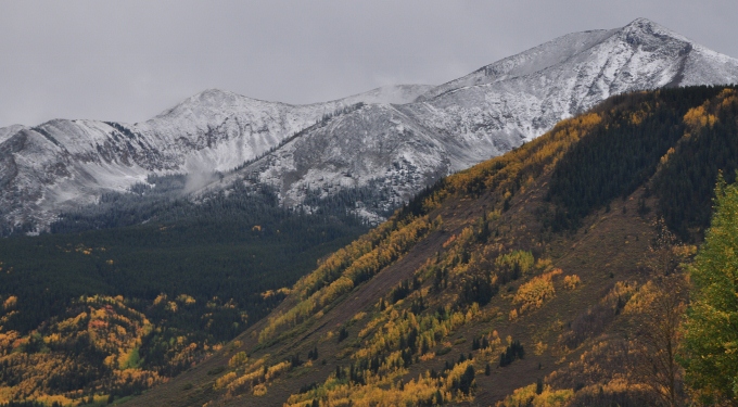 snow-dusted mountains are a back drop to the hills filled with autumn colors, Colorado